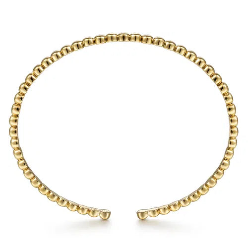 Gold beaded bracelet on a white background side view