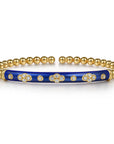 Gold and blue enamel bracelet with floral designs and diamonds on a white background