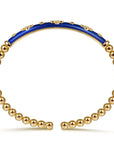 Gold beaded bracelet with a blue accent on a white background side view