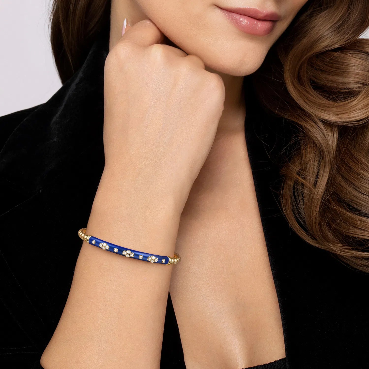 Close-up of a woman's arm wearing a blue bracelet with gold accents.