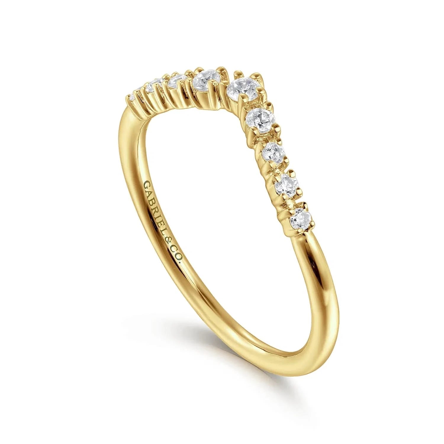 angled view of curved Gold ring with diamonds on a white background