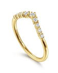angled view of curved Gold ring with diamonds on a white background