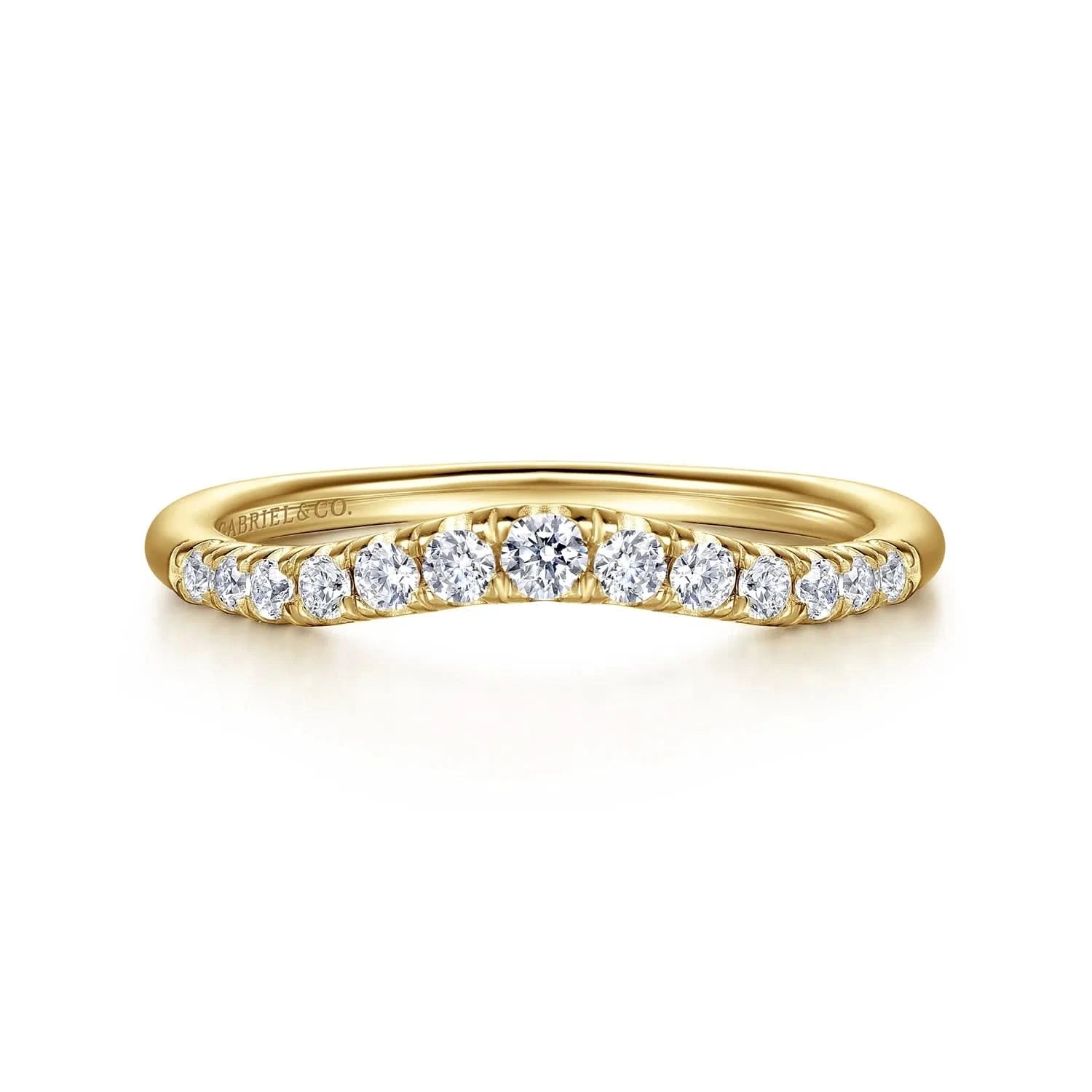 A Gabriel & Co. curved anniversary band, showcasing a contoured line of round brilliant-cut diamonds set in high-polish 14k yellow gold, sculpted to fit flush against an engagement ring.