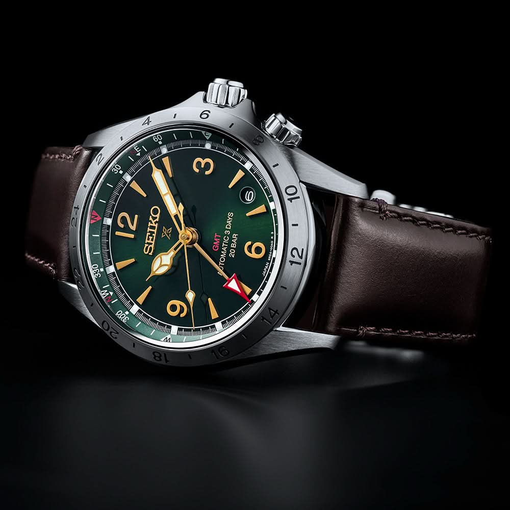 Seiko watch with a dark green face and brown leather strap on a black background