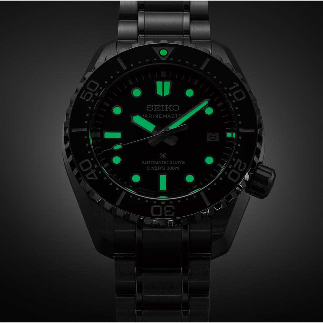 Black Seiko watch with green glowing face on a dark background