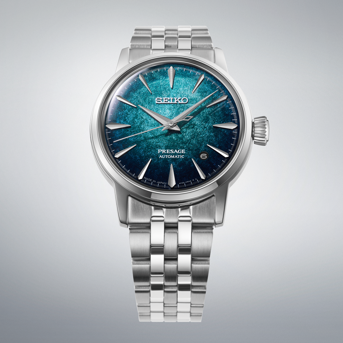 A Seiko Presage Automatic watch with a silver stainless steel case and link bracelet, featuring a textured blue and teal dial.