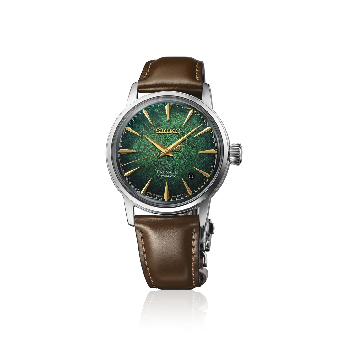 A Seiko wristwatch with a green textured dial, gold-tone hands and hour markers, and a brown leather strap, shown against a plain white background with a subtle reflection.