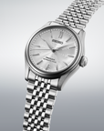 Silver Seiko watch with a detailed face on a light gray background