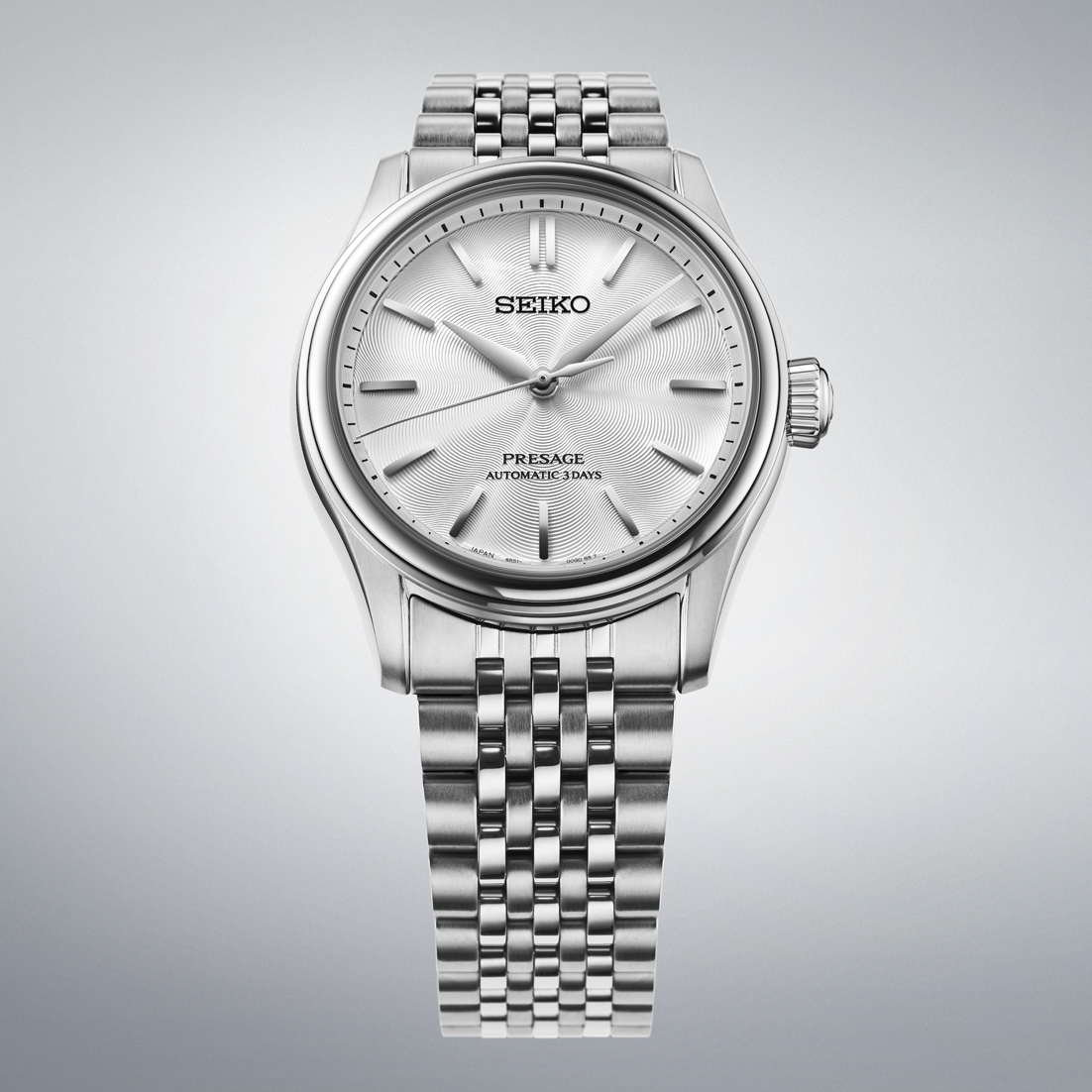Silver Seiko watch on a gray background facing