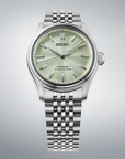 Silver Seiko watch with a light green face on a gray background