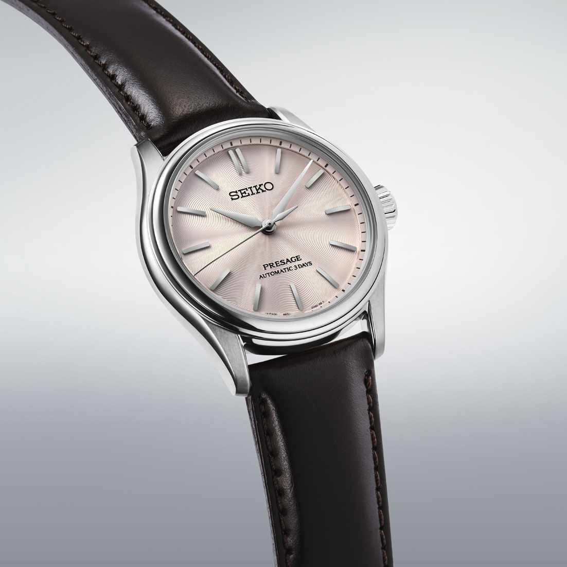 Seiko watch with a brown leather strap on a light gray background angled