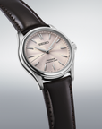 Seiko watch with a brown leather strap on a light gray background angled