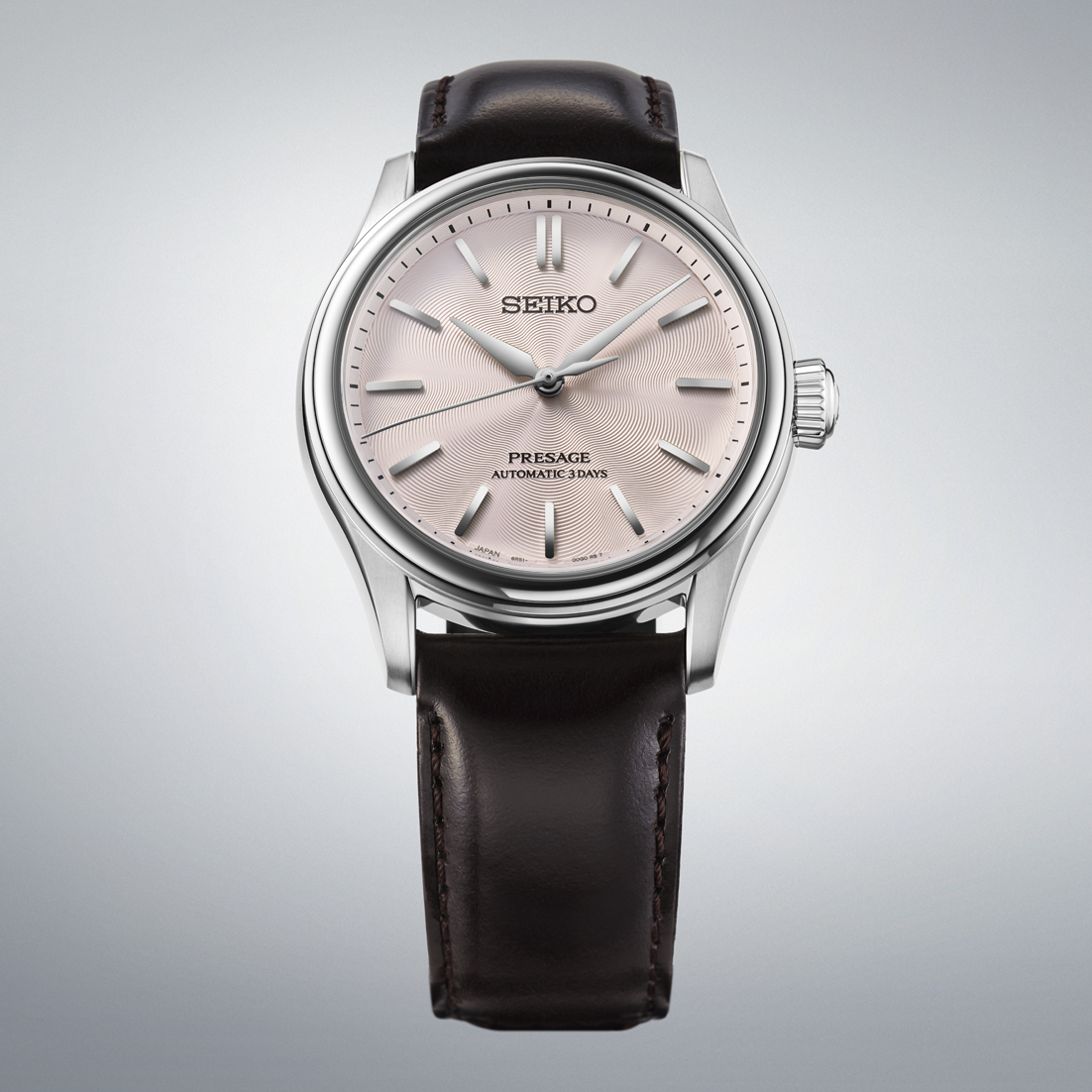 Seiko watch with brown  leather strap  and pink dial on a gray background