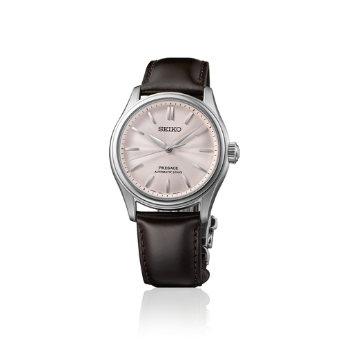 Seiko watch with black leather strap and soft pink dial on a white background