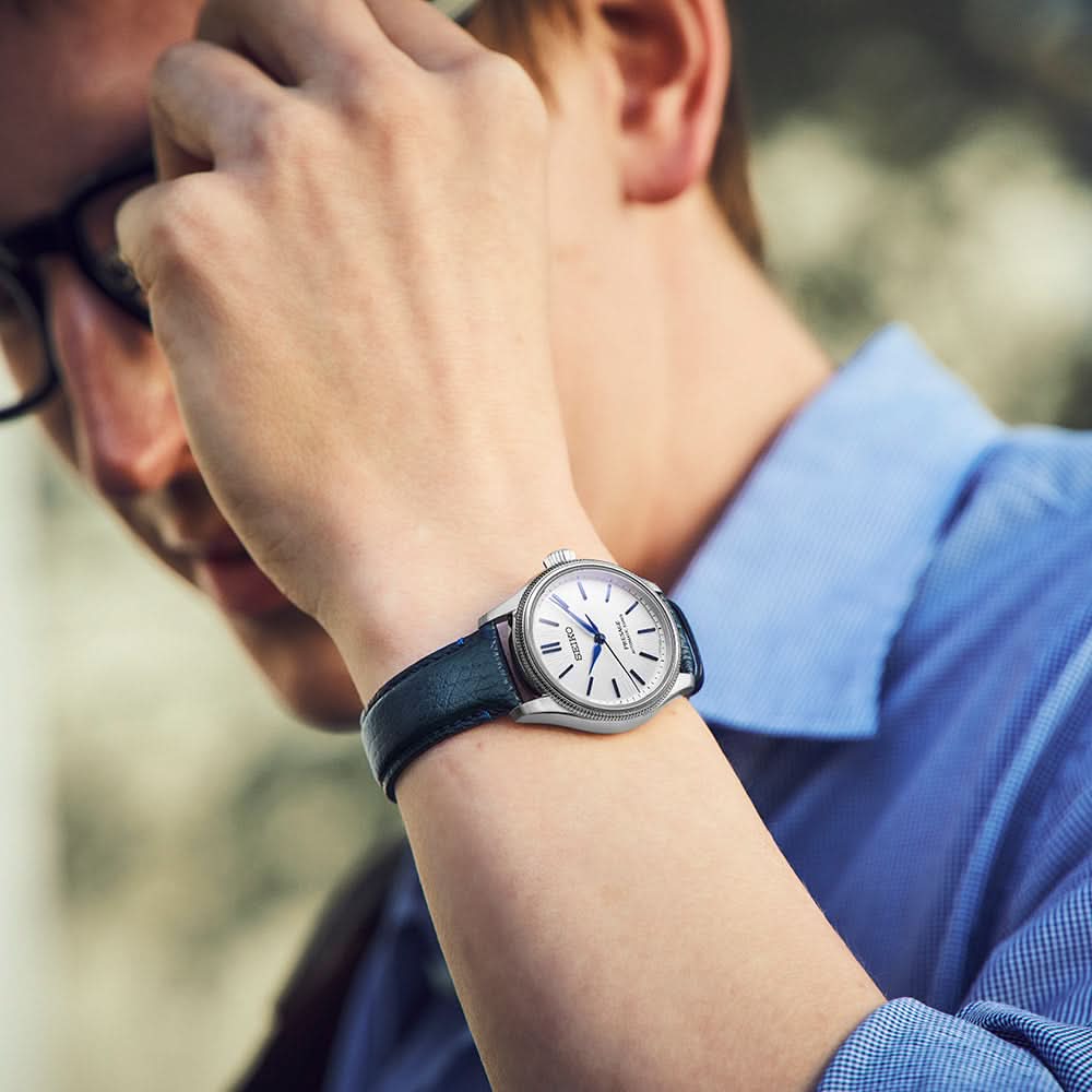 Close-up of a person wearing a watch with a blurred background