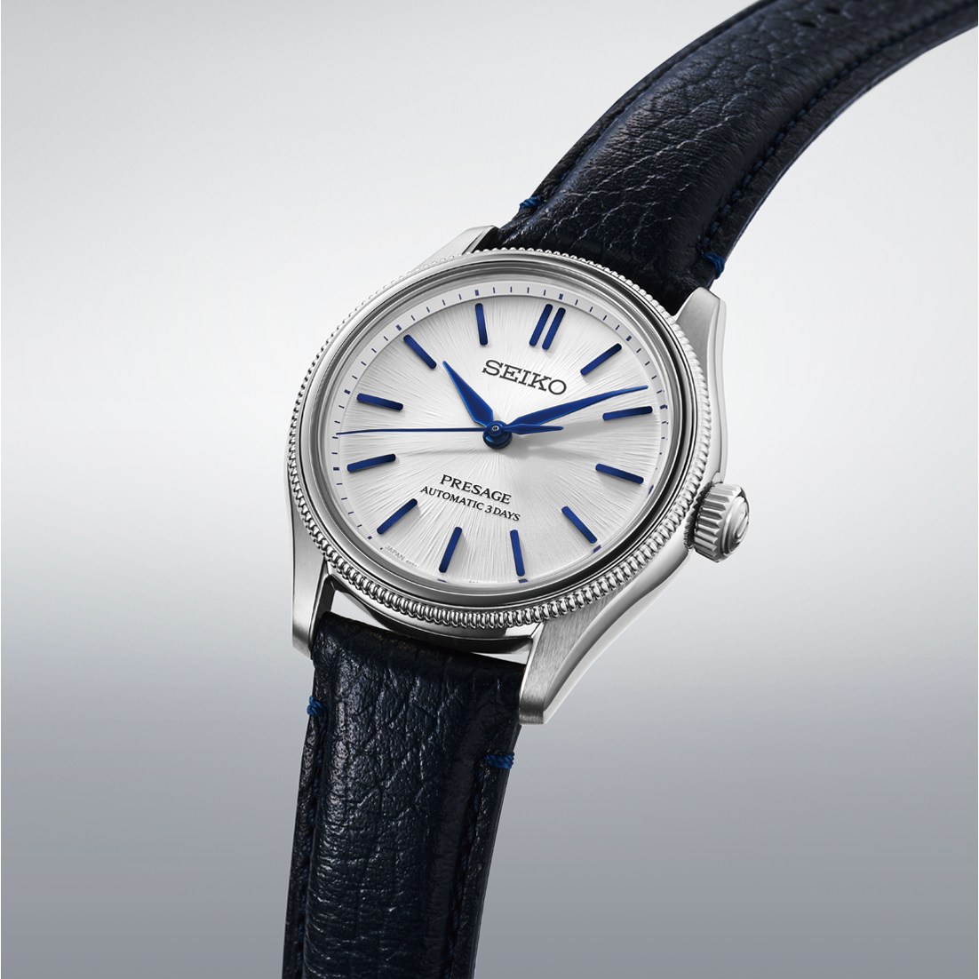 Seiko watch with black leather strap on a light gray background