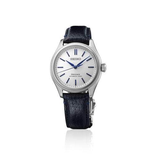 A front view of the Seiko Presage Classic Series 145th Anniversary watch HCC004J1 showcasing its compact 36mm stainless steel case, finely detailed textured bezel, raw-silk textured shironeri white dial with curved cobalt blue hands and applied indices, and a deep navy blue leather strap on a white background.