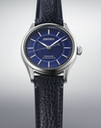 Seiko watch with blue dial and black leather strap on a light gray background