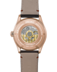 back of Seiko watch with rose gold tone case and beige leather strap on a white background