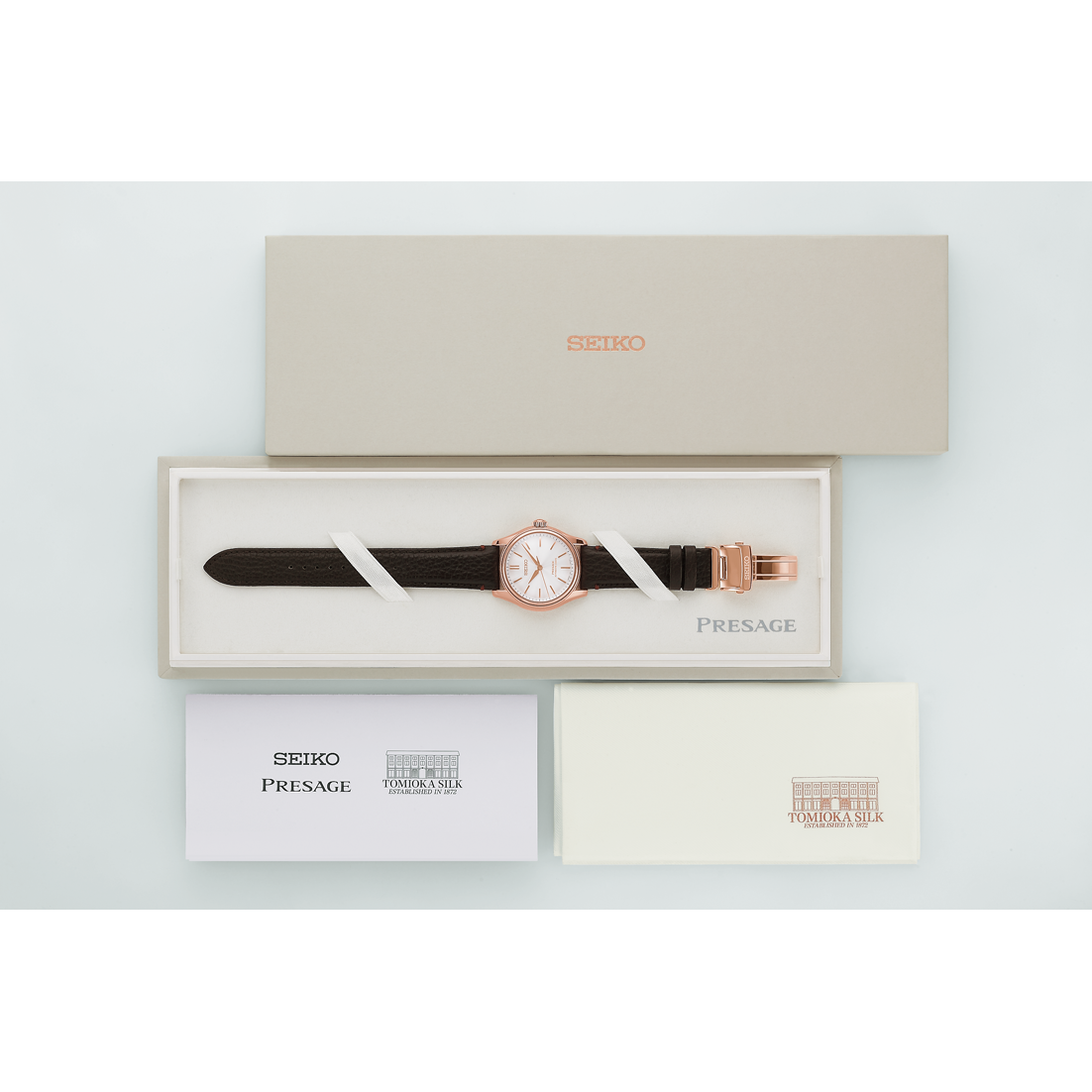 Seiko Presage watch with brown strap in a box on a light gray background