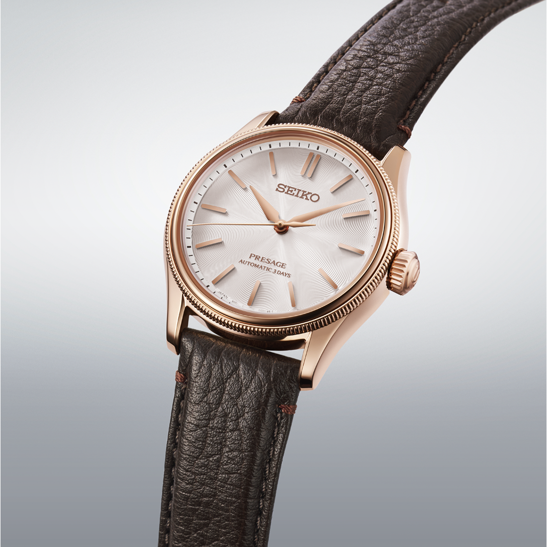 Seiko watch with brown leather strap on a light gray background angled
