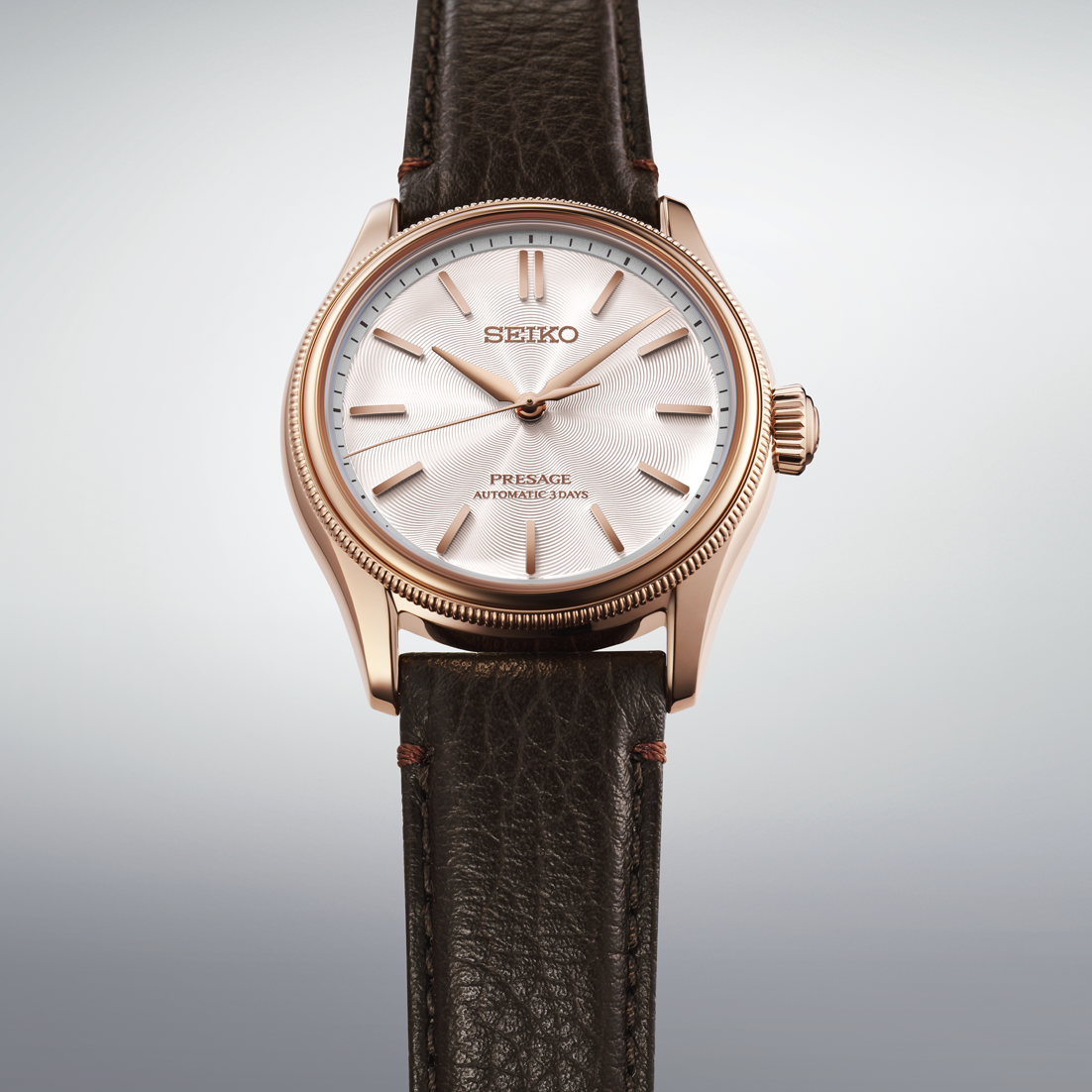 Seiko watch with brown leather strap on a light gray background