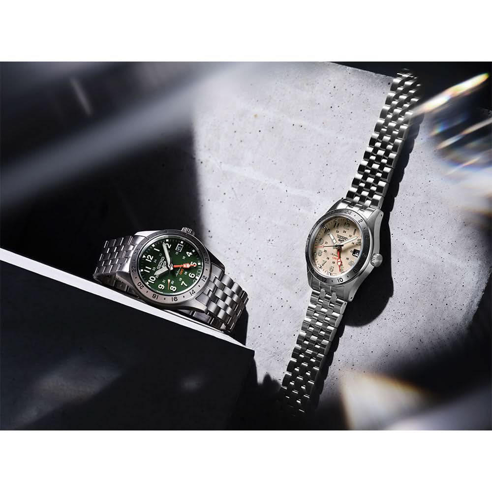 Two watches on a textured surface with a blurred background