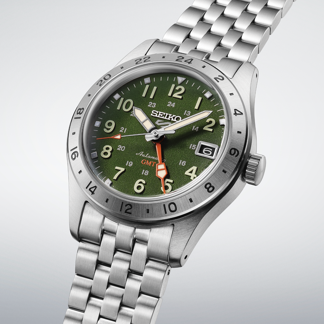 A Seiko dive watch with a green dial, silver stainless steel case and link bracelet, featuring a rotating bezel and a date window.