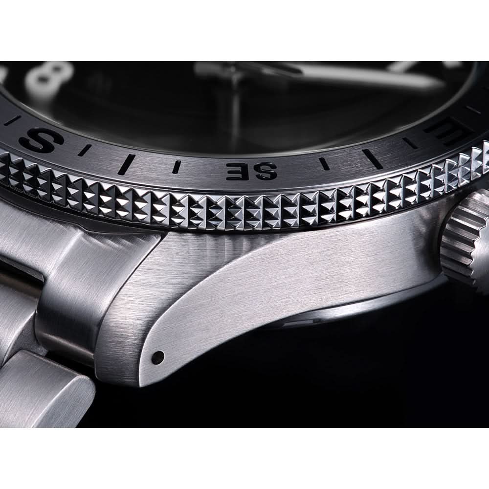 Close-up of a silver watch with detailed bezel and crown.