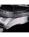 Close-up of a silver watch with detailed bezel and crown.