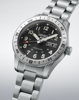 Silver Seiko watch with black dial on a light gray background- angled