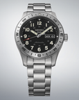 Seiko watch with black dial and silver metal bracelet on a light gray background