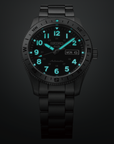 Black Seiko watch with green glowing digits on a dark background
