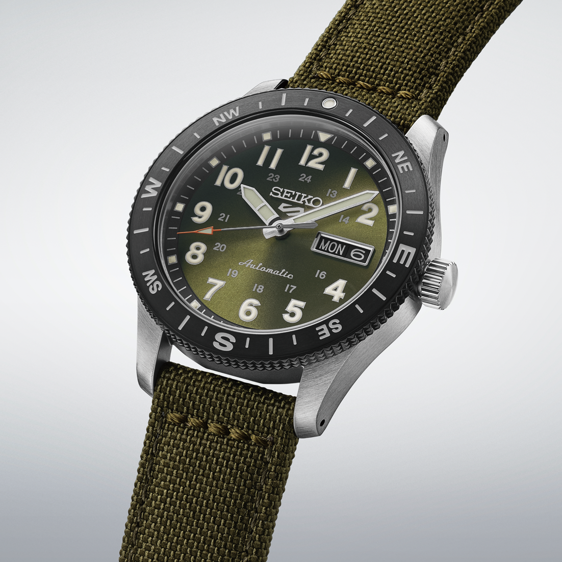 Seiko watch with green strap and green dial on a light gray background- angled