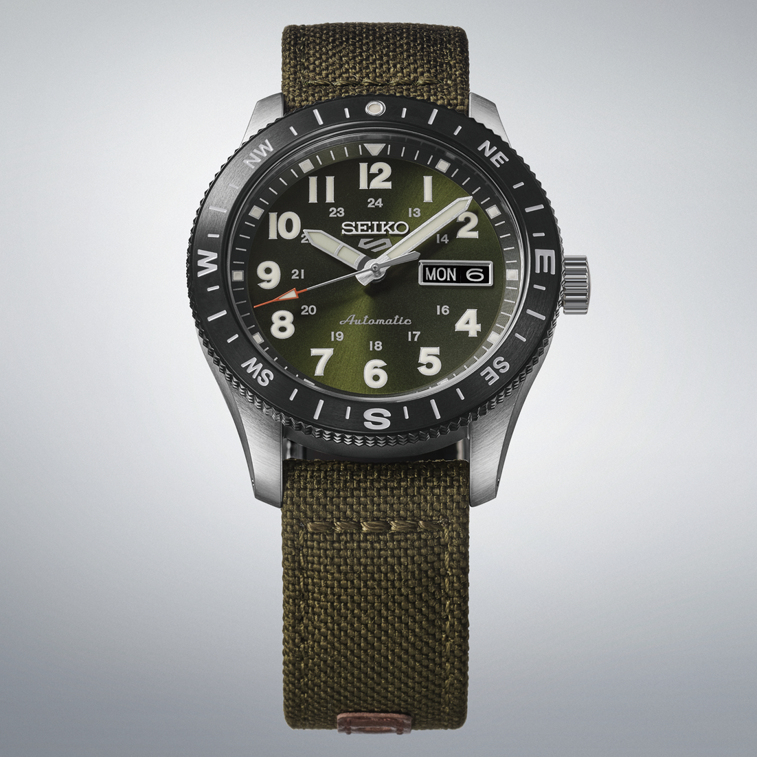 Seiko watch with green strap and face on a light gray background
