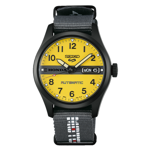 Seiko watch with a black case, bright yellow dial, and a black textured fabric strap featuring white and red lettering.
