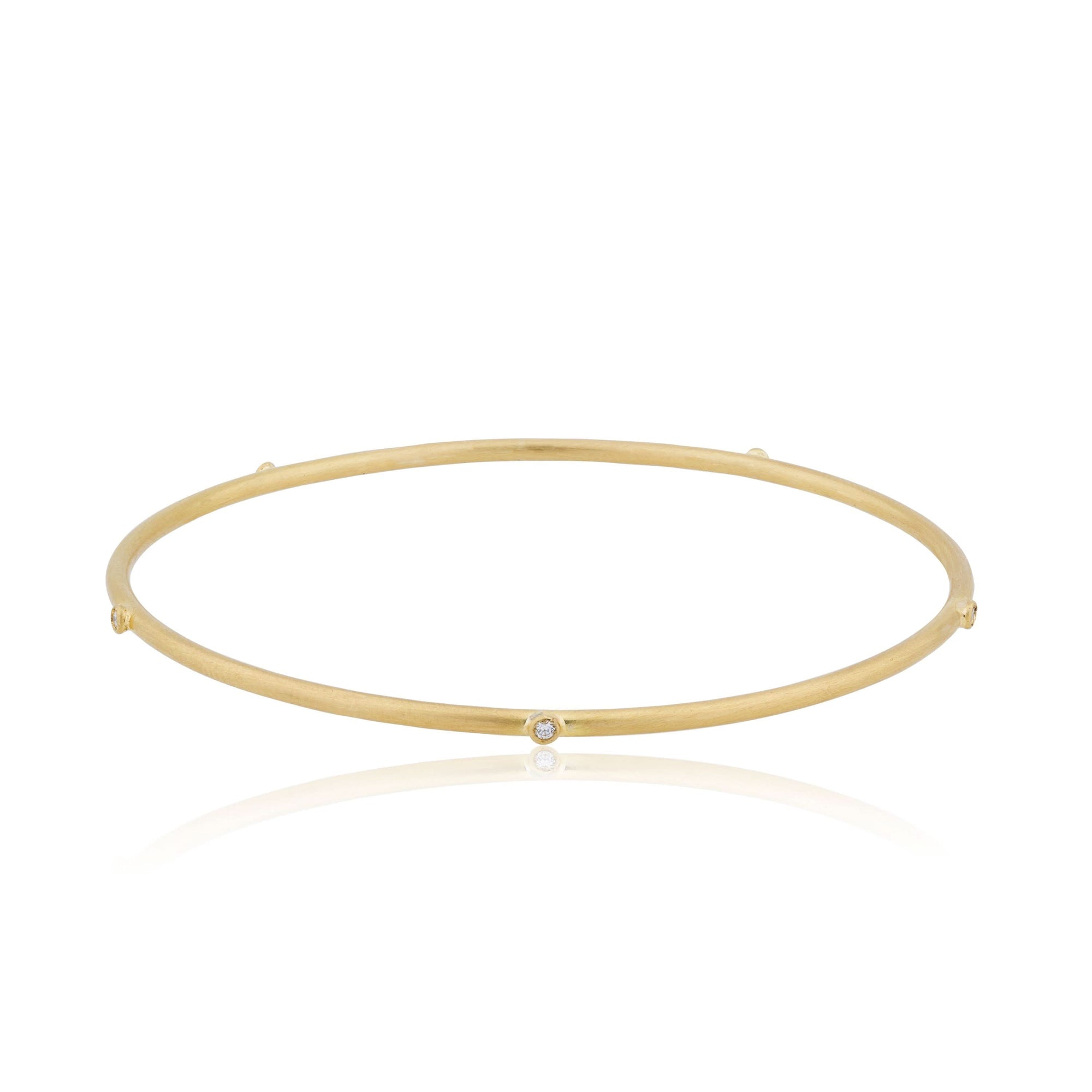 Gold bracelet with small diamond stations on a white background