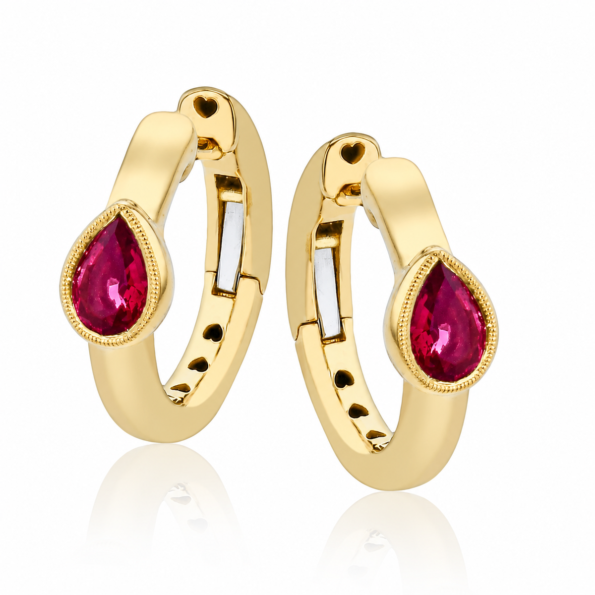 A pair of gold huggie hoop earrings with teardrop-shaped ruby gemstones, displayed on a clean white background with a soft reflection below.