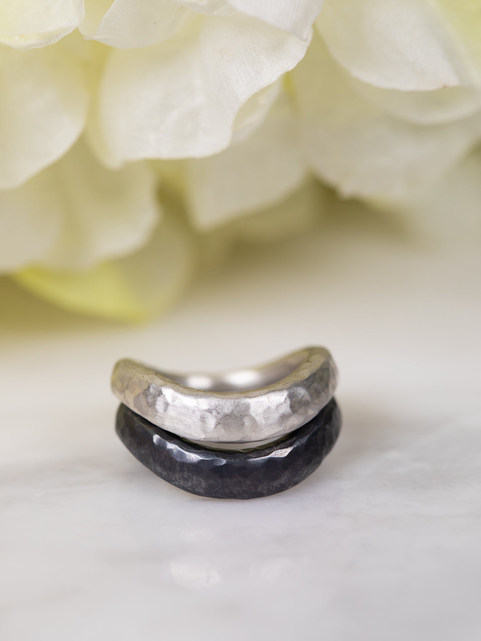 silver and black pair of rings stacked together on a blurred background