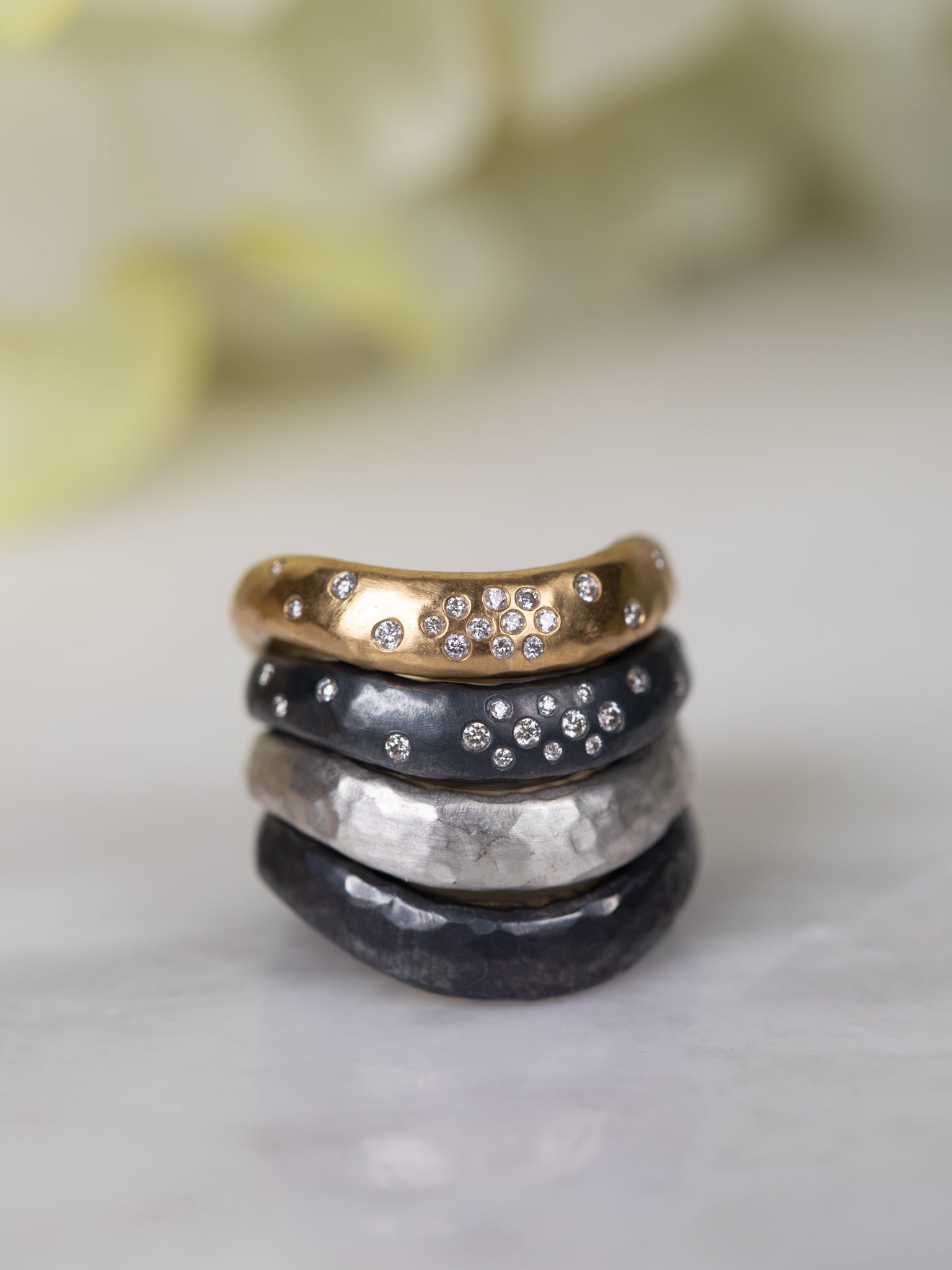 Stack of five rings with different designs and colors on a light background