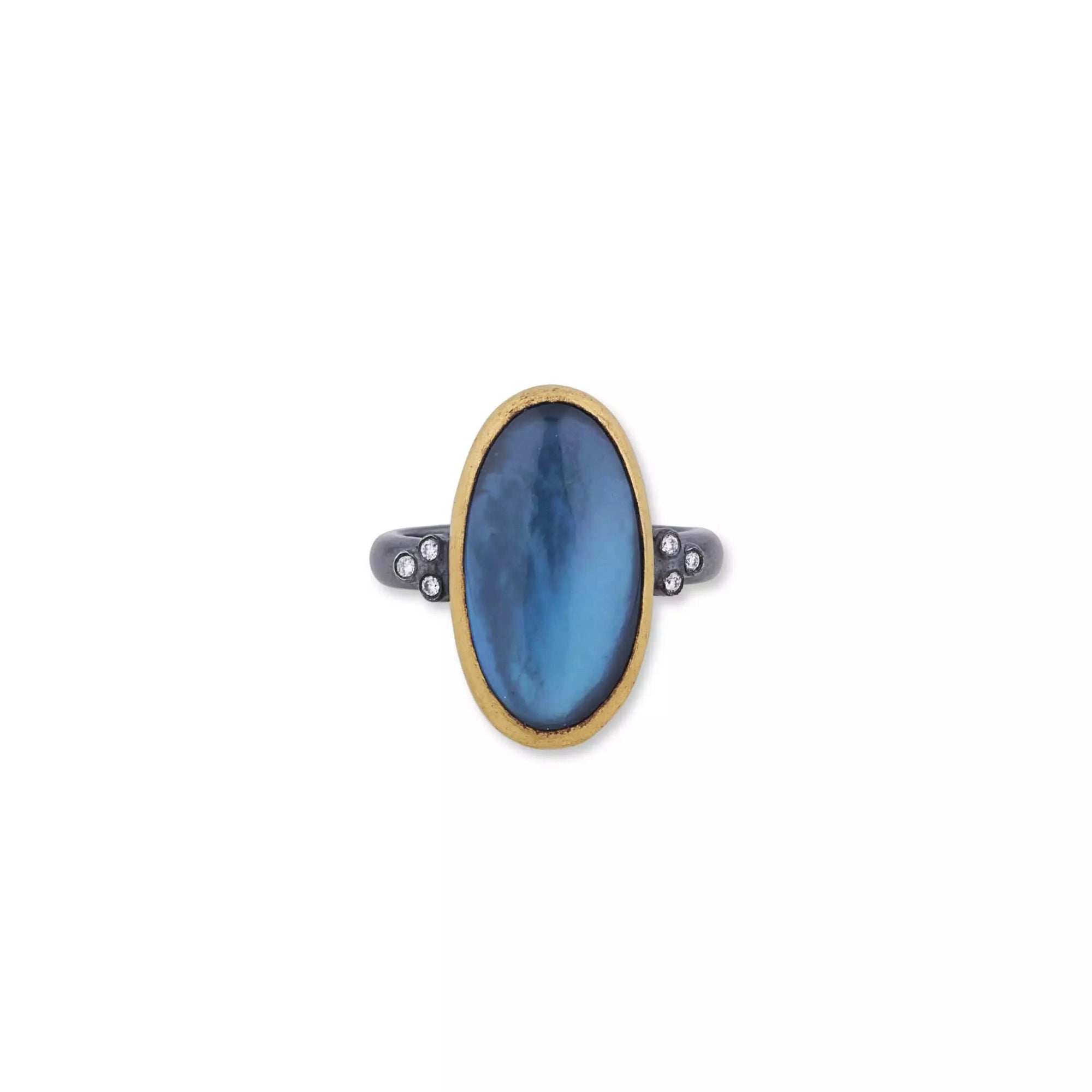 A hand-hammered Lika Behar Mare Nostrum statement ring, showcasing an east-west oval cabochon London blue topaz and mother-of-pearl doublet bezel-set in rich 24k yellow gold, surrounded by an oxidized sterling silver border with diamond accents.