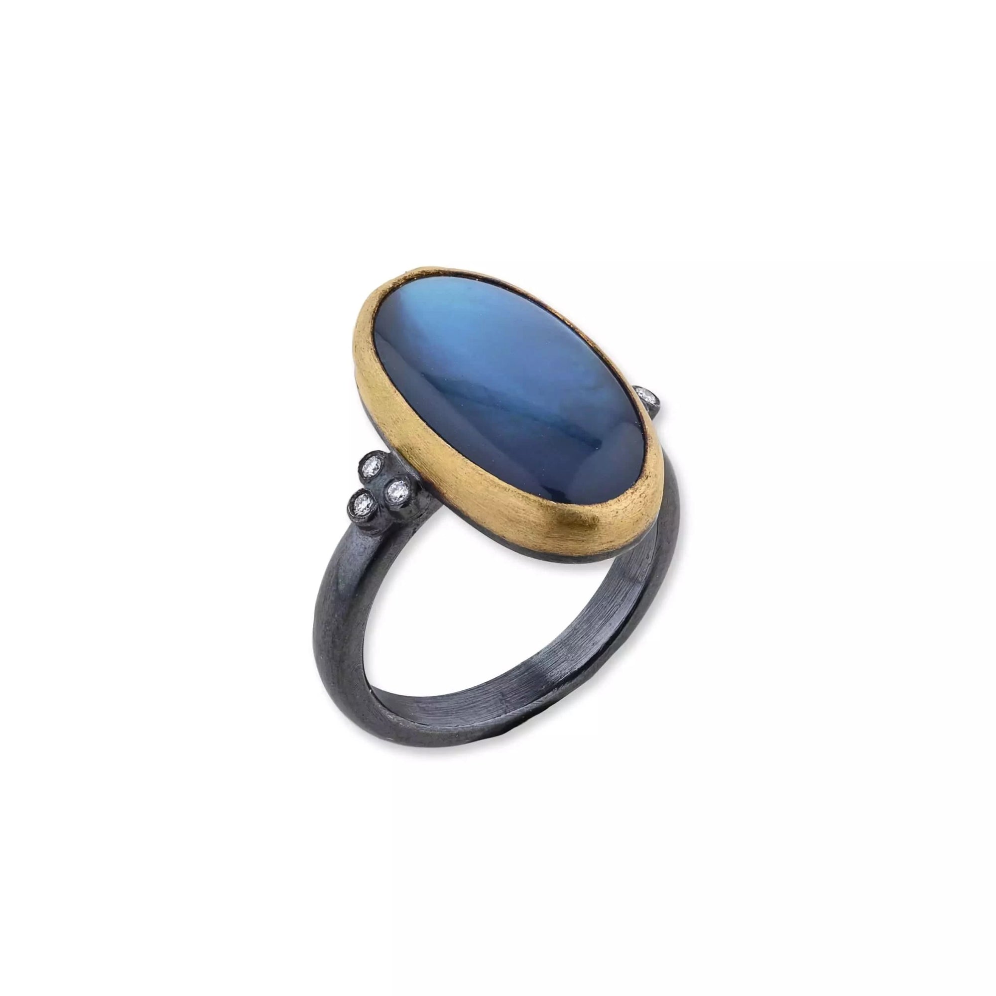 Ring with blue stone and gold band on a white background angled view
