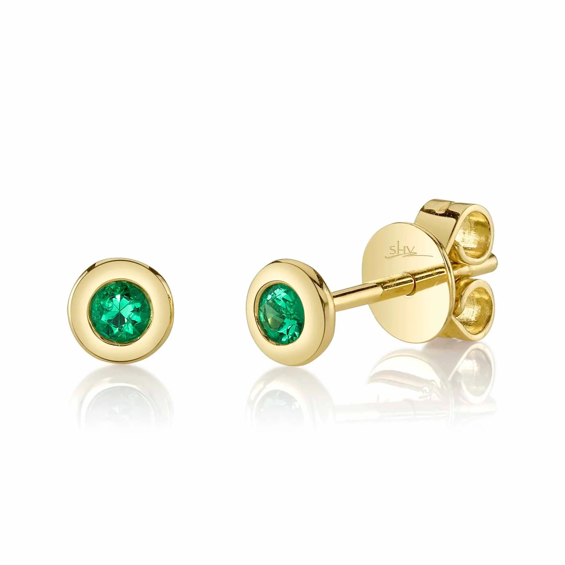 Gold earrings with round emeralds on a white background