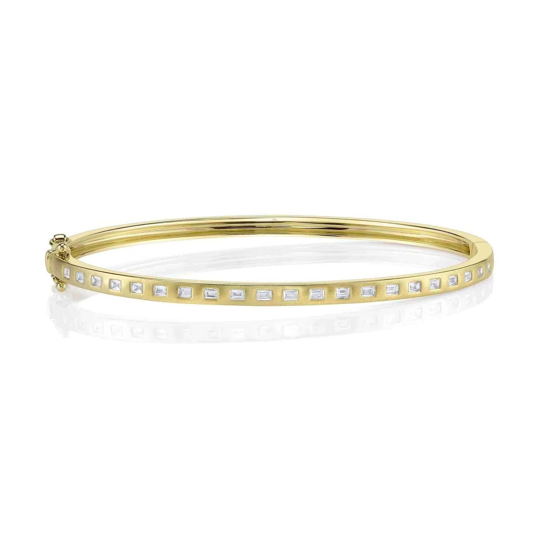 Gold bangle with small diamonds on a white background