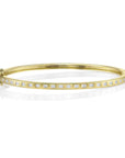 Gold bangle with small diamonds on a white background