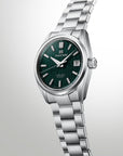 Silver watch with a green face on a light gray background