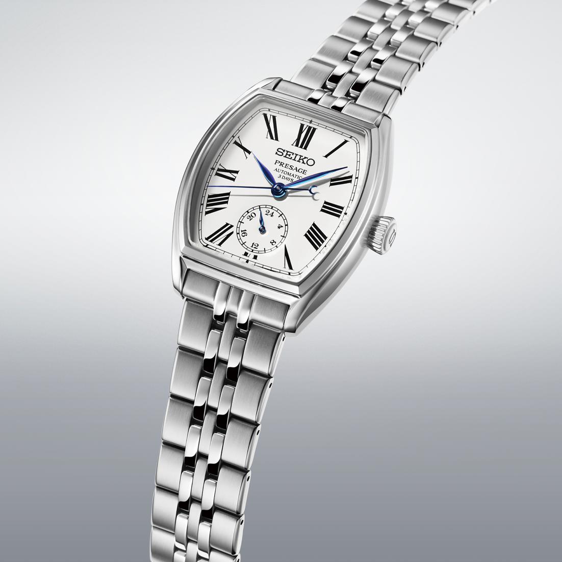 angled close up view of silver watch with white dial and blue hands on a gradient grey background