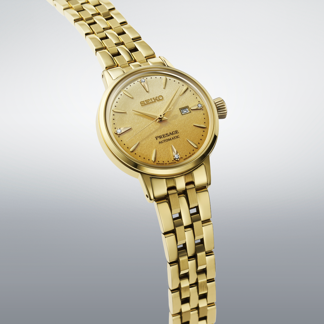 Gold tone Seiko watch angled on a gradient gray background