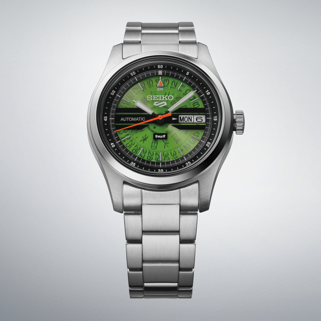 Silver Seiko watch with green face on a light gray background