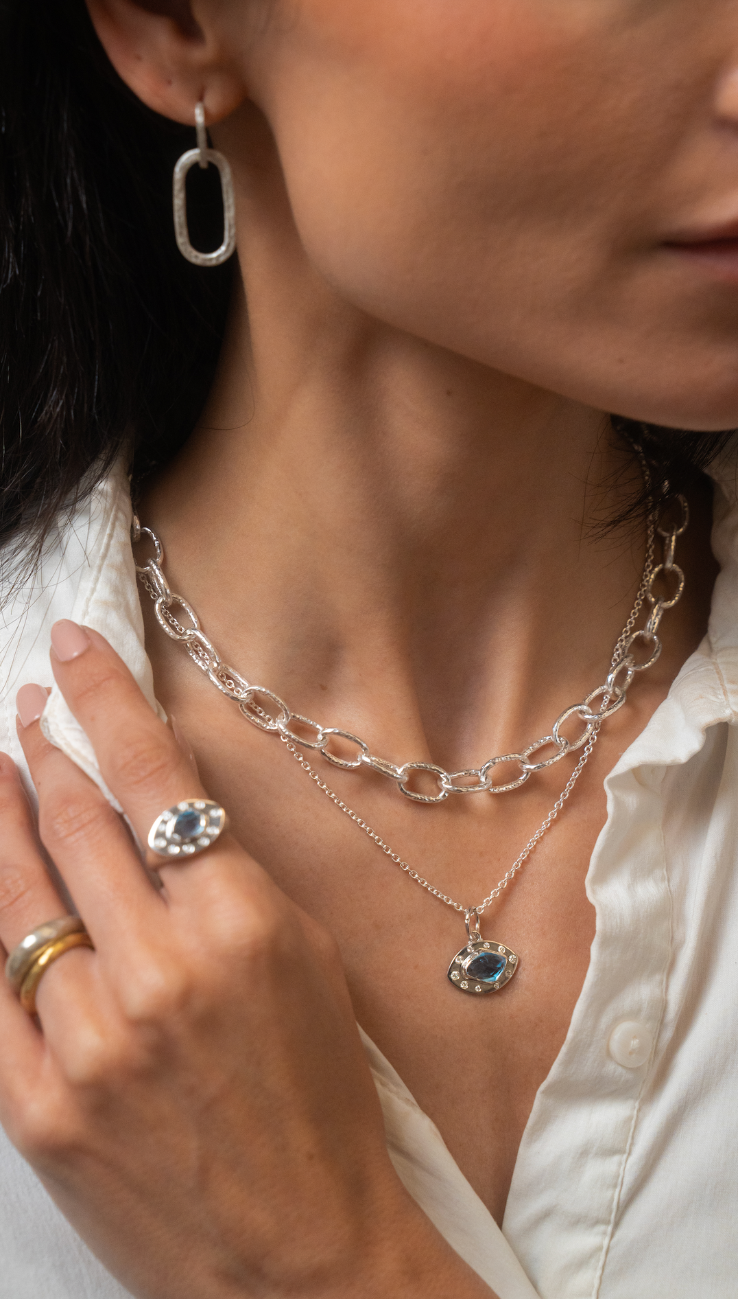 Close-up of a person wearing silver jewelry with a white shirt